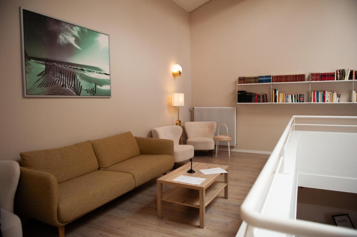 un salon avec un canapé et une table dans l'établissement Logis Thermal, à Saubusse