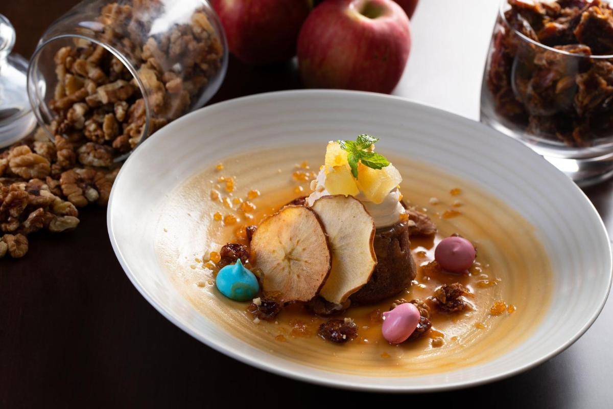 a white bowl of food with apples and nuts at Holiday Inn Agra MG Road an IHG Hotel in Agra