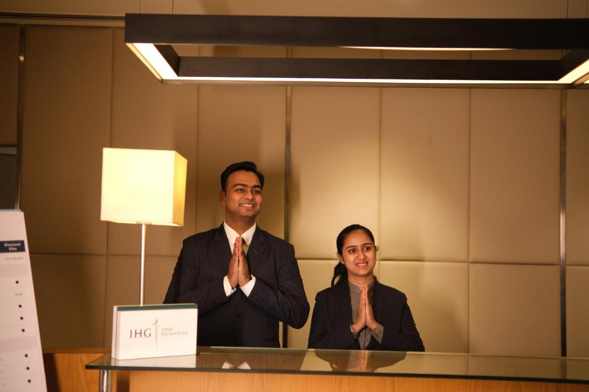 a couple of people sitting at a desk at Holiday Inn Agra MG Road an IHG Hotel in Agra