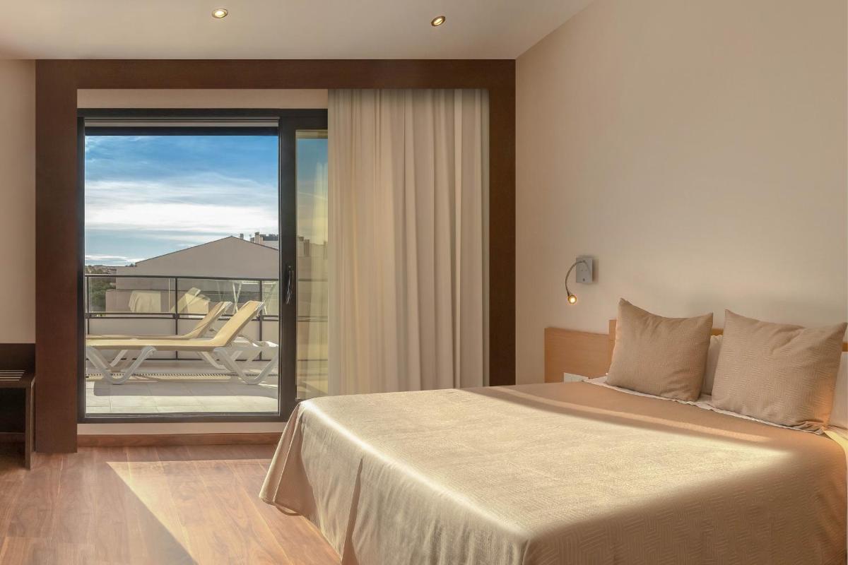 Cama o camas de una habitación en RH Don Carlos & Spa