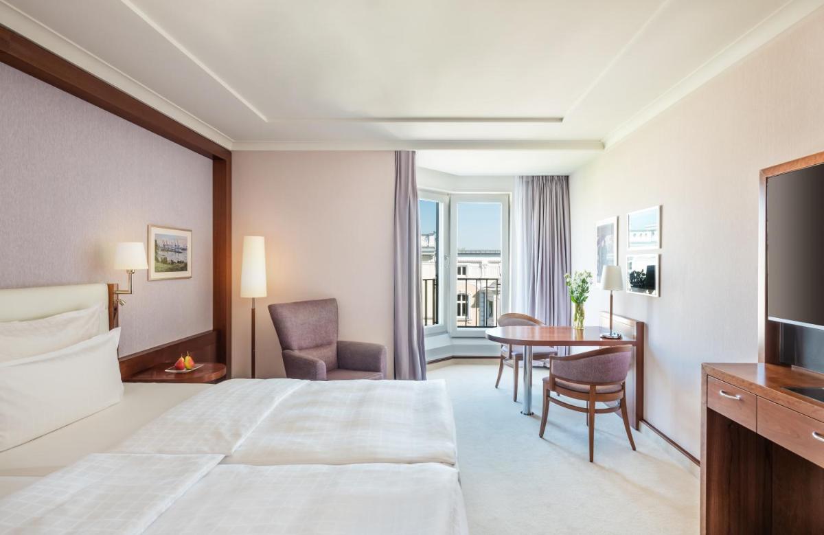ein Hotelzimmer mit einem Bett und einem Tisch in der Unterkunft GRAND ELYSEE Hamburg in Hamburg ein Hotelzimmer mit einem Bett und einem Tisch in der Unterkunft GRAND ELYSEE Hamburg in Hamburg