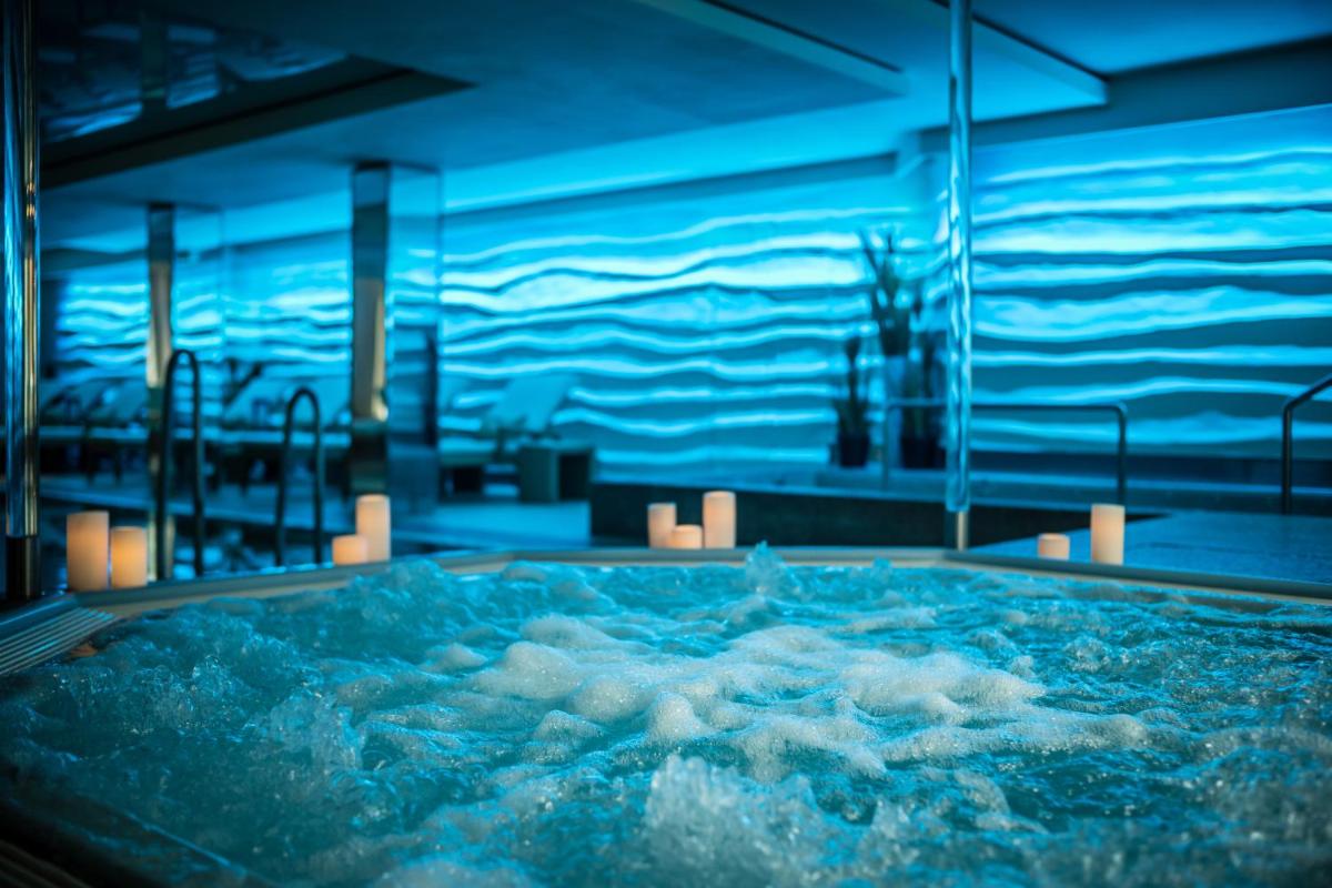 eine große Badewanne mit blauem Wasser in einem Zimmer in der Unterkunft GRAND ELYSEE Hamburg in Hamburg eine große Badewanne mit blauem Wasser in einem Zimmer in der Unterkunft GRAND ELYSEE Hamburg in Hamburg