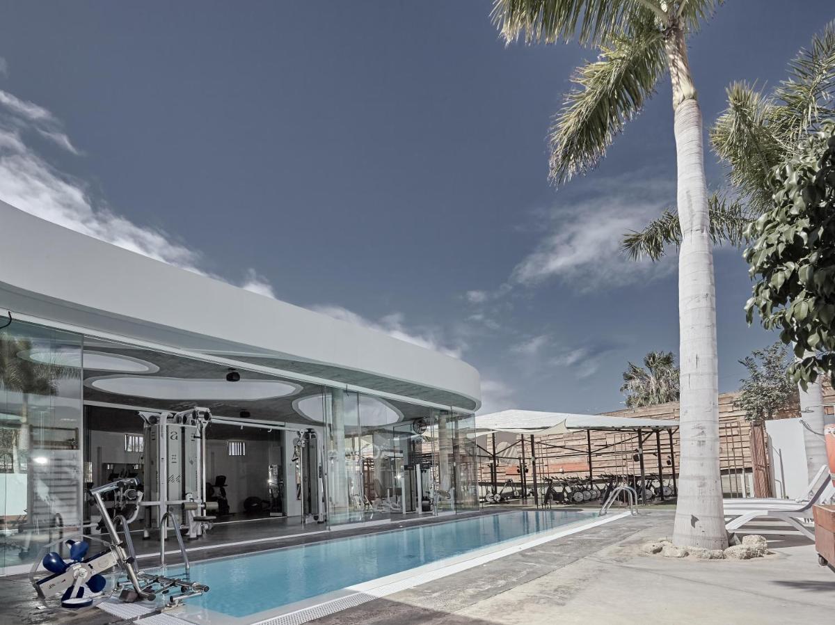 un edificio con piscina y palmeras en Hotel Baobab Suites, en Adeje
