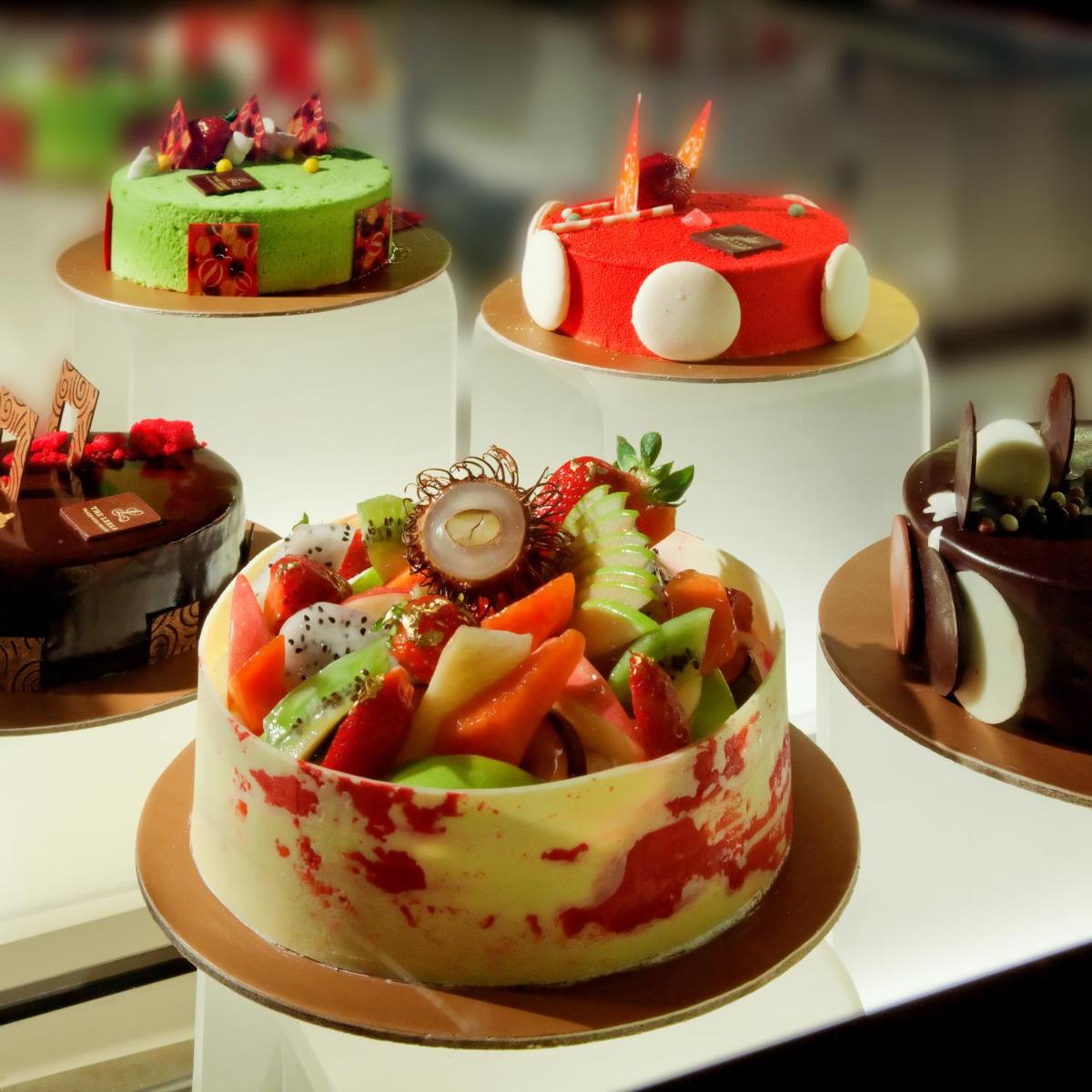 a variety of cakes on display in a display case at The Leela Palace Chennai in Chennai a variety of cakes on display in a display case at The Leela Palace Chennai in Chennai
