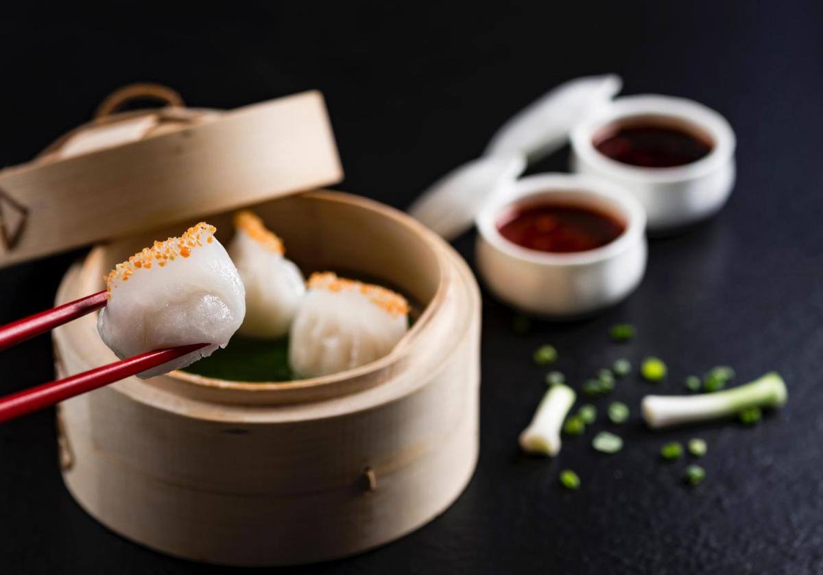 a pair of chopsticks holding sushi in a box at The Leela Palace Chennai in Chennai a pair of chopsticks holding sushi in a box at The Leela Palace Chennai in Chennai
