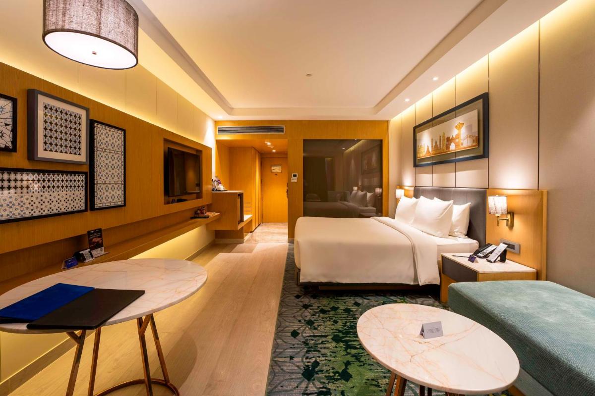 a hotel room with a bed and a couch at Radisson Blu Hotel Amritsar in Amritsar