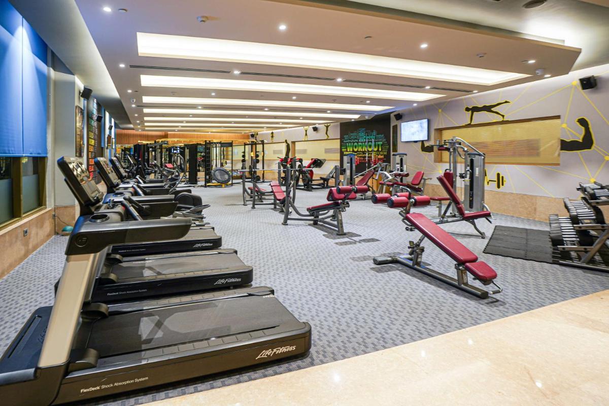 a gym with treadmills and machines in a room at Radisson Blu Hotel Amritsar in Amritsar