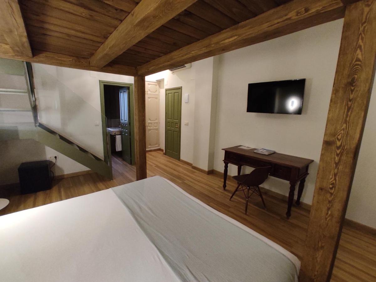 Un dormitorio con una cama y un escritorio con televisión. en Hotel Leonor de Aquitania, en Cuenca