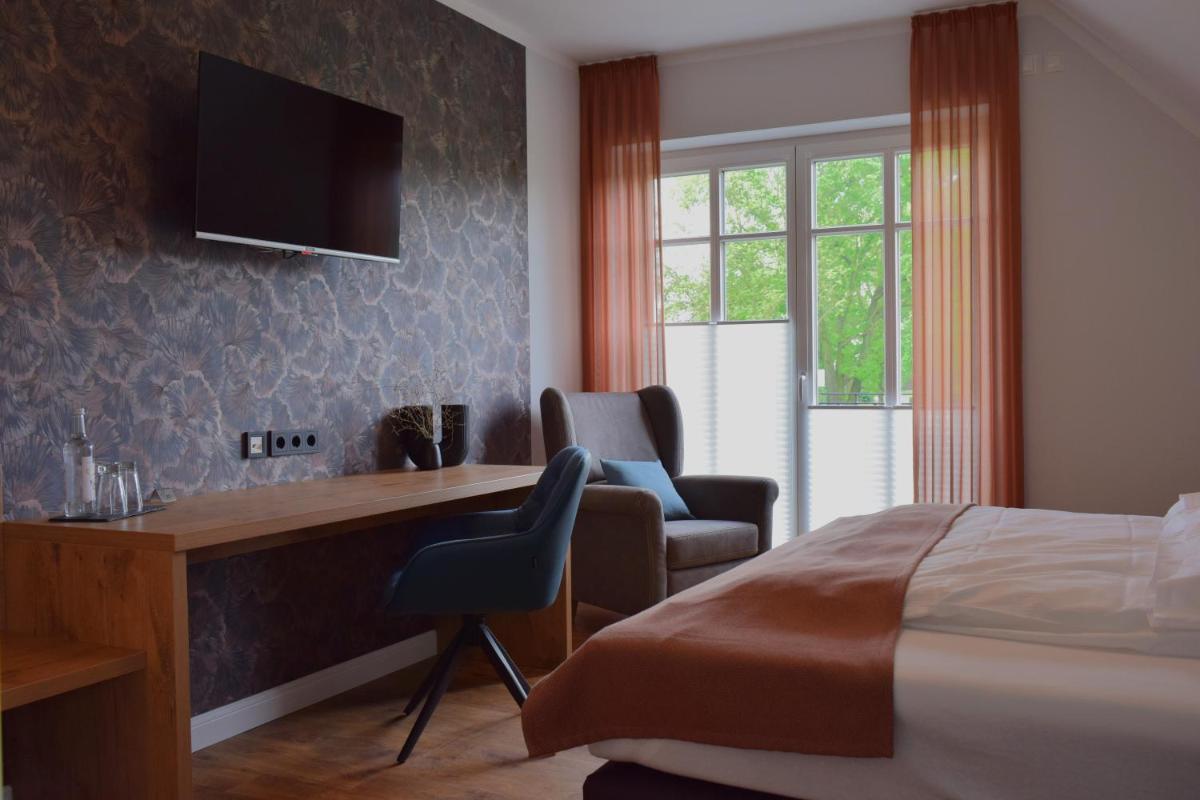 ein Schlafzimmer mit einem Bett, einem Schreibtisch und einem Stuhl in der Unterkunft DZ/EZ Lodberger Scheunencafe in Löningen