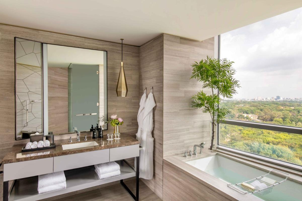 a bathroom with a tub and a sink and a window at Four Seasons Hotel Bengaluru at Embassy ONE in Bengaluru a bathroom with a tub and a sink and a window at Four Seasons Hotel Bengaluru at Embassy ONE in Bengaluru