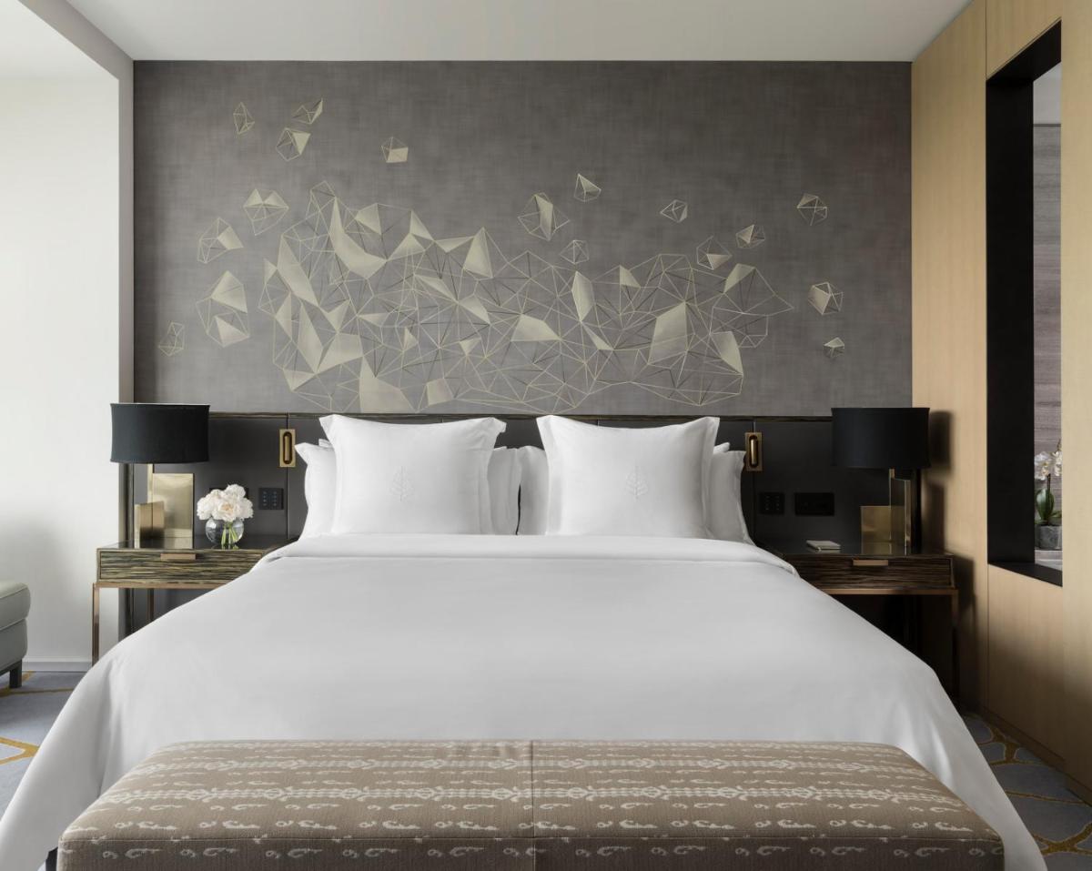 a bedroom with a large white bed and a wall with butterflies at Four Seasons Hotel Bengaluru at Embassy ONE in Bengaluru a bedroom with a large white bed and a wall with butterflies at Four Seasons Hotel Bengaluru at Embassy ONE in Bengaluru
