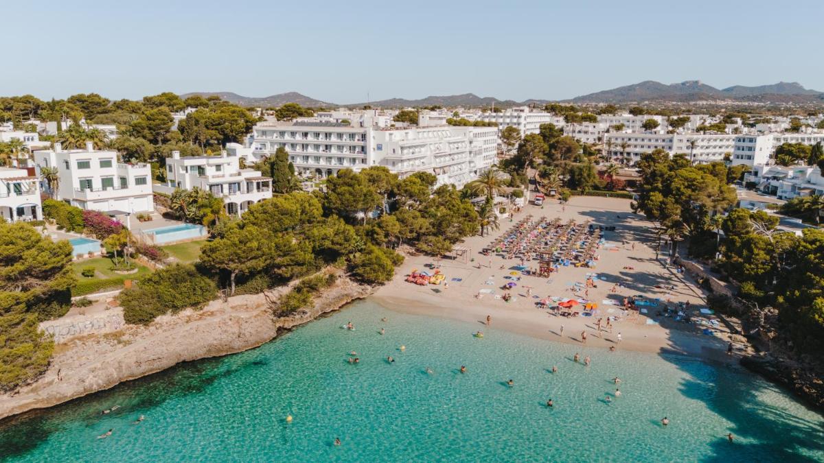 Una vista aérea de una playa con gente en el agua. en Grupotel Rocador - Adults Only, en Cala d´Or