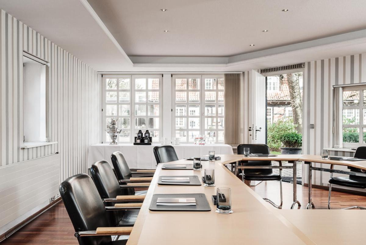 ein Konferenzraum mit Tischen und Stühlen und Fenstern in der Unterkunft Althoff Hotel Fürstenhof in Celle + 37 Fotos