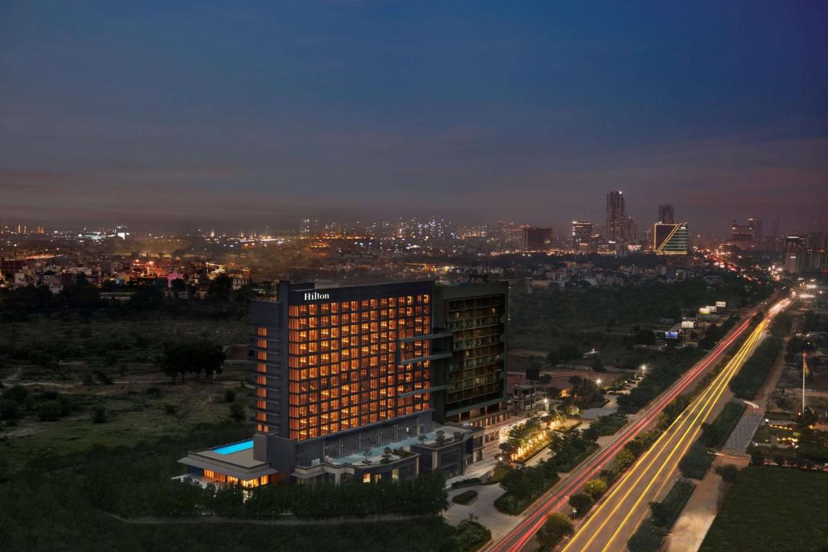 a building with lights on in a city at night at Hilton Gurugram Baani City Centre in Gurgaon
