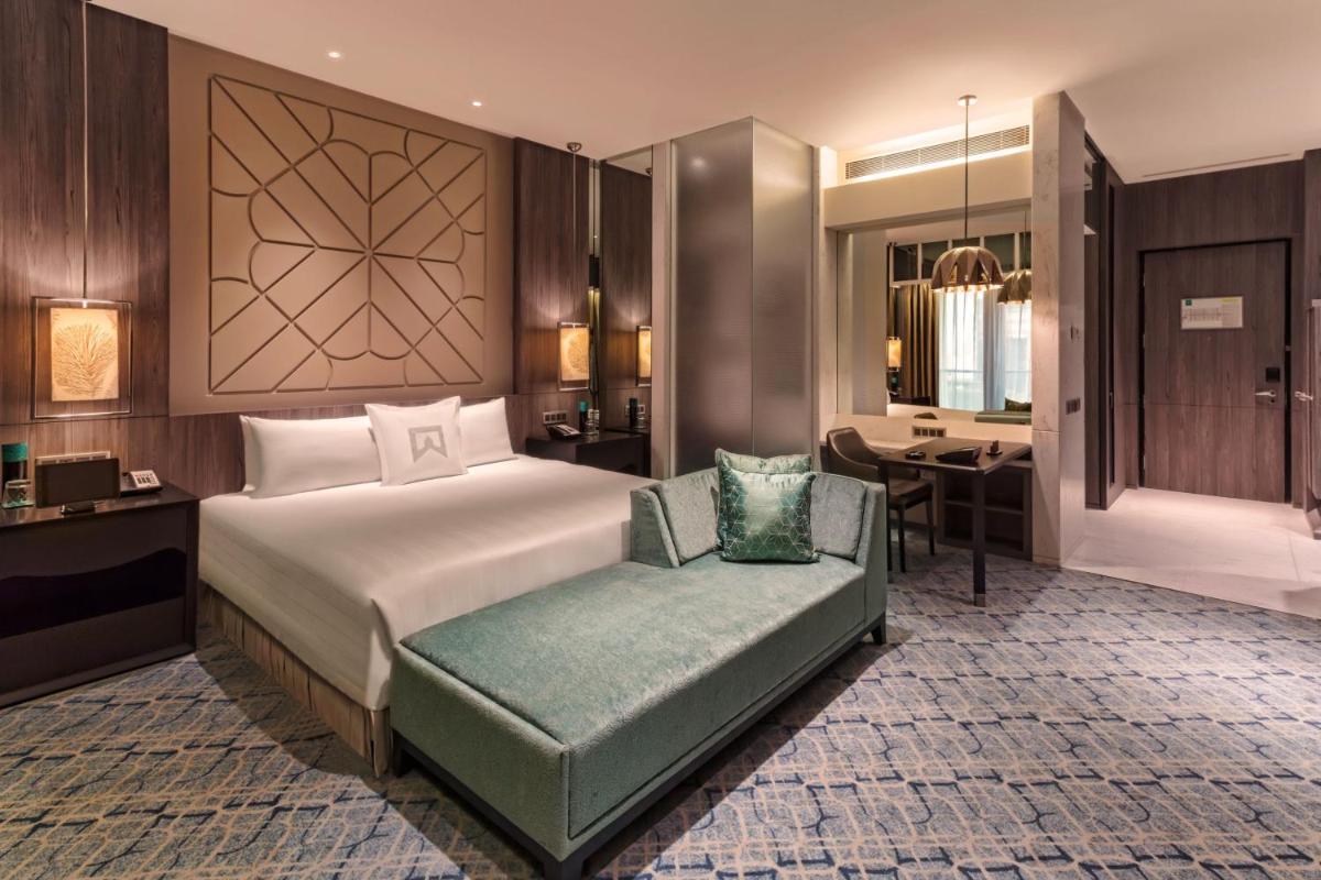 a bedroom with a bed and a chair and a desk at ITC Kohenur, a Luxury Collection Hotel, Hyderabad in Hyderabad