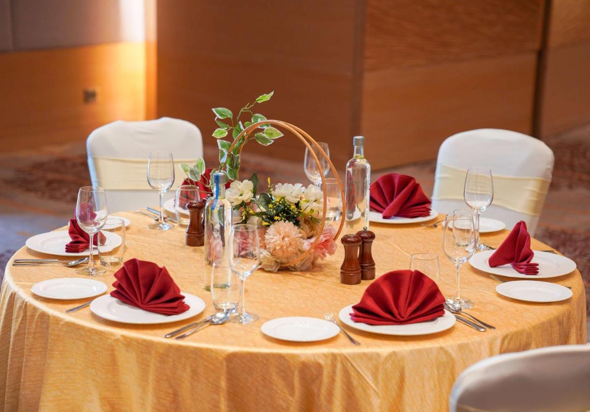 a table with red napkins and wine glasses on it at Radisson Blu Hotel Amritsar in Amritsar