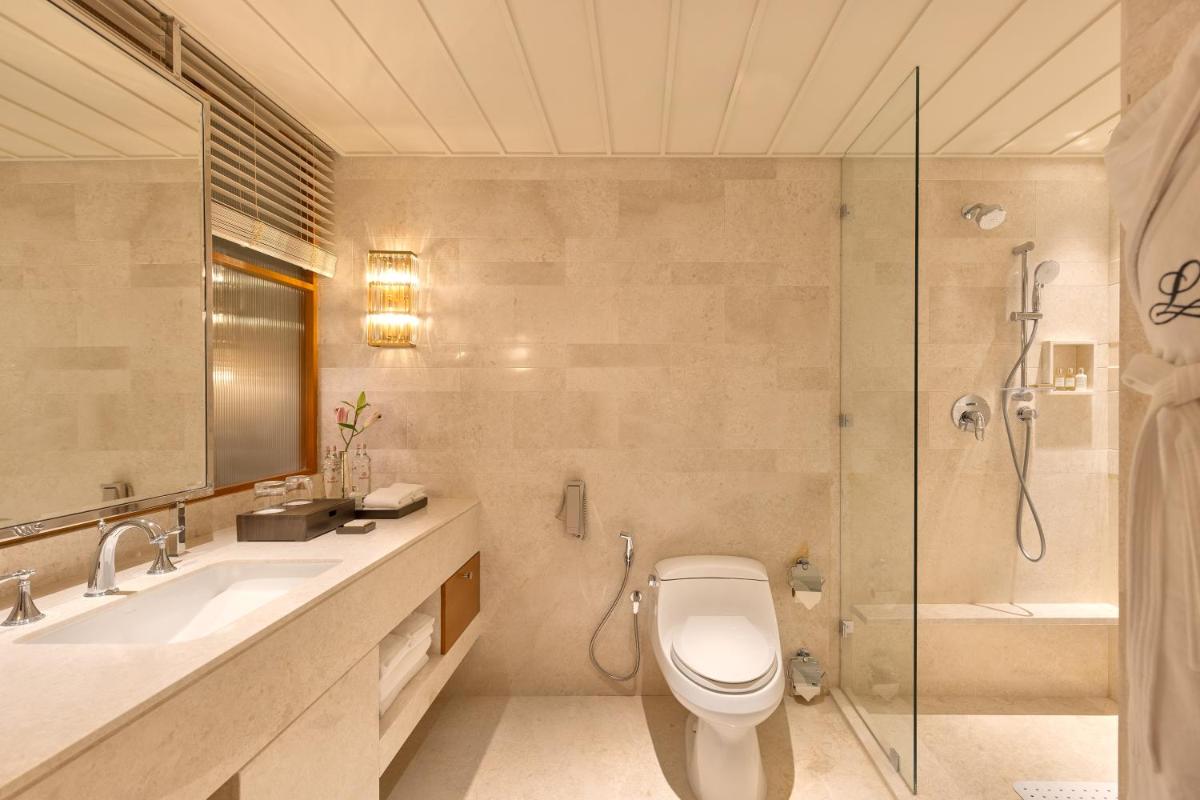 a bathroom with a toilet and a sink and a shower at The Leela Hyderabad Banjara Hills in Hyderabad