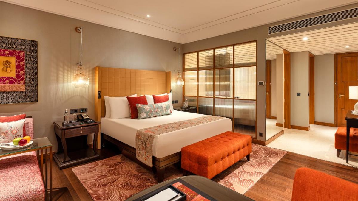 a hotel room with a bed and a desk at The Leela Hyderabad Banjara Hills in Hyderabad