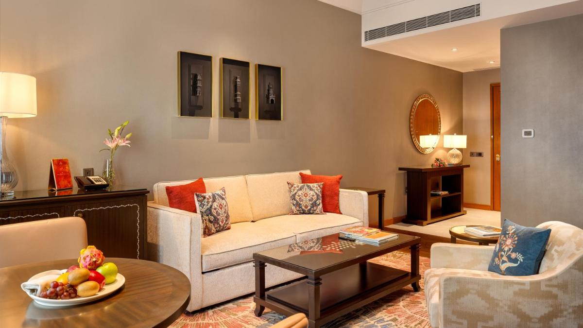 a living room with a couch and a table at The Leela Hyderabad Banjara Hills in Hyderabad