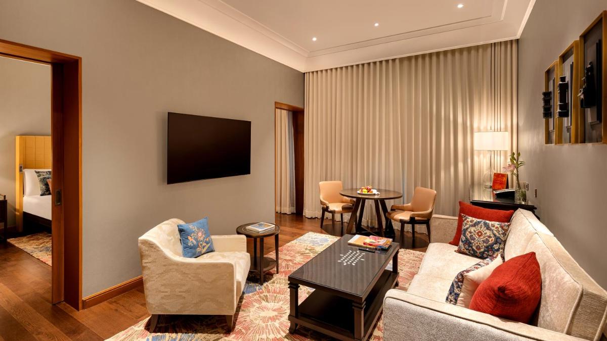 a living room with a couch and a table at The Leela Hyderabad Banjara Hills in Hyderabad