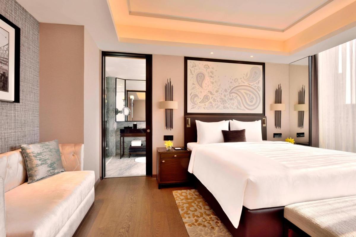 a bedroom with a large white bed and a couch at JW Marriott Hotel Kolkata in Kolkata