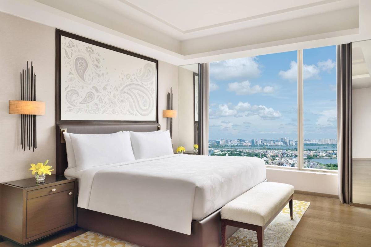 a bedroom with a large bed and a large window at JW Marriott Hotel Kolkata in Kolkata
