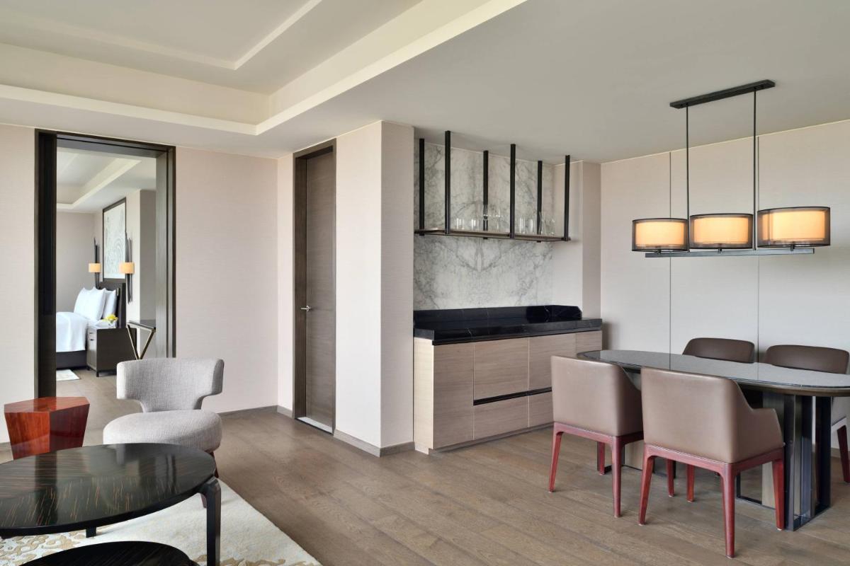a kitchen and dining room with a table and chairs at JW Marriott Hotel Kolkata in Kolkata