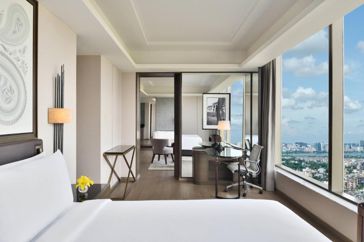 a hotel room with a bed and a view of a bedroom at JW Marriott Hotel Kolkata in Kolkata