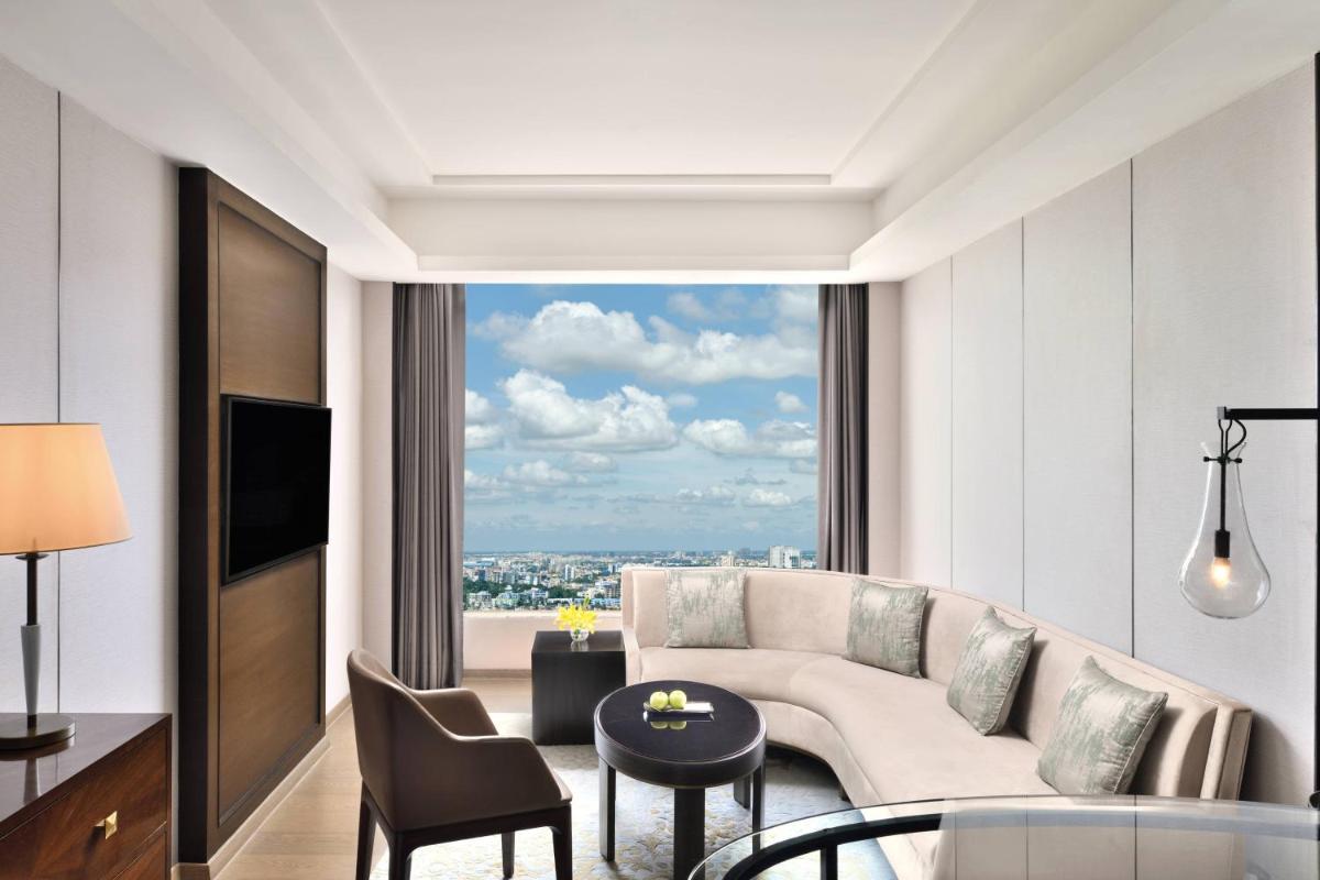 a living room with a couch and a large window at JW Marriott Hotel Kolkata in Kolkata