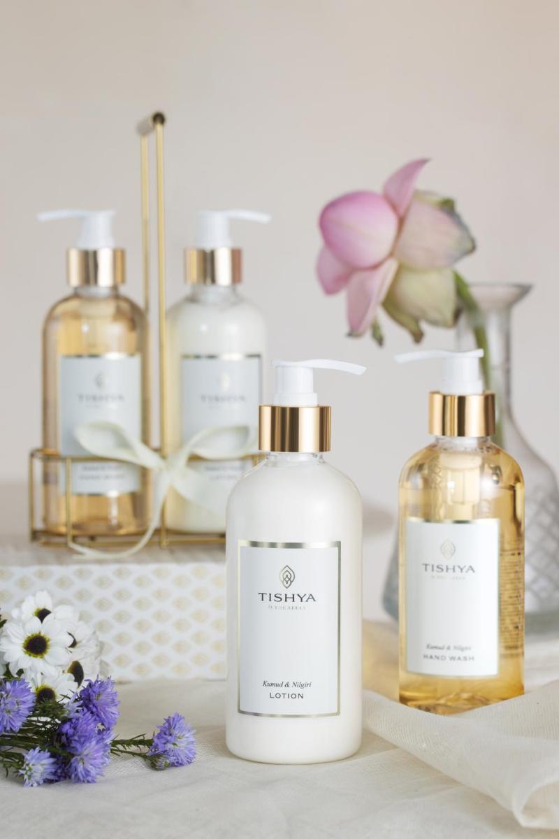 a group of three bottles of perfume on a table with flowers at The Leela Palace Chennai in Chennai a group of three bottles of perfume on a table with flowers at The Leela Palace Chennai in Chennai