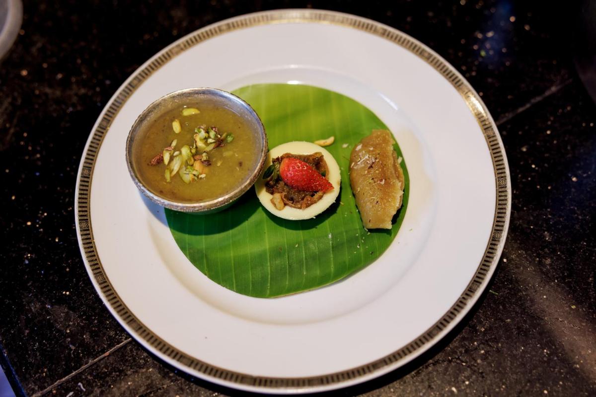a plate of food with a egg on a banana leaf at The Leela Palace Chennai in Chennai a plate of food with a egg on a banana leaf at The Leela Palace Chennai in Chennai