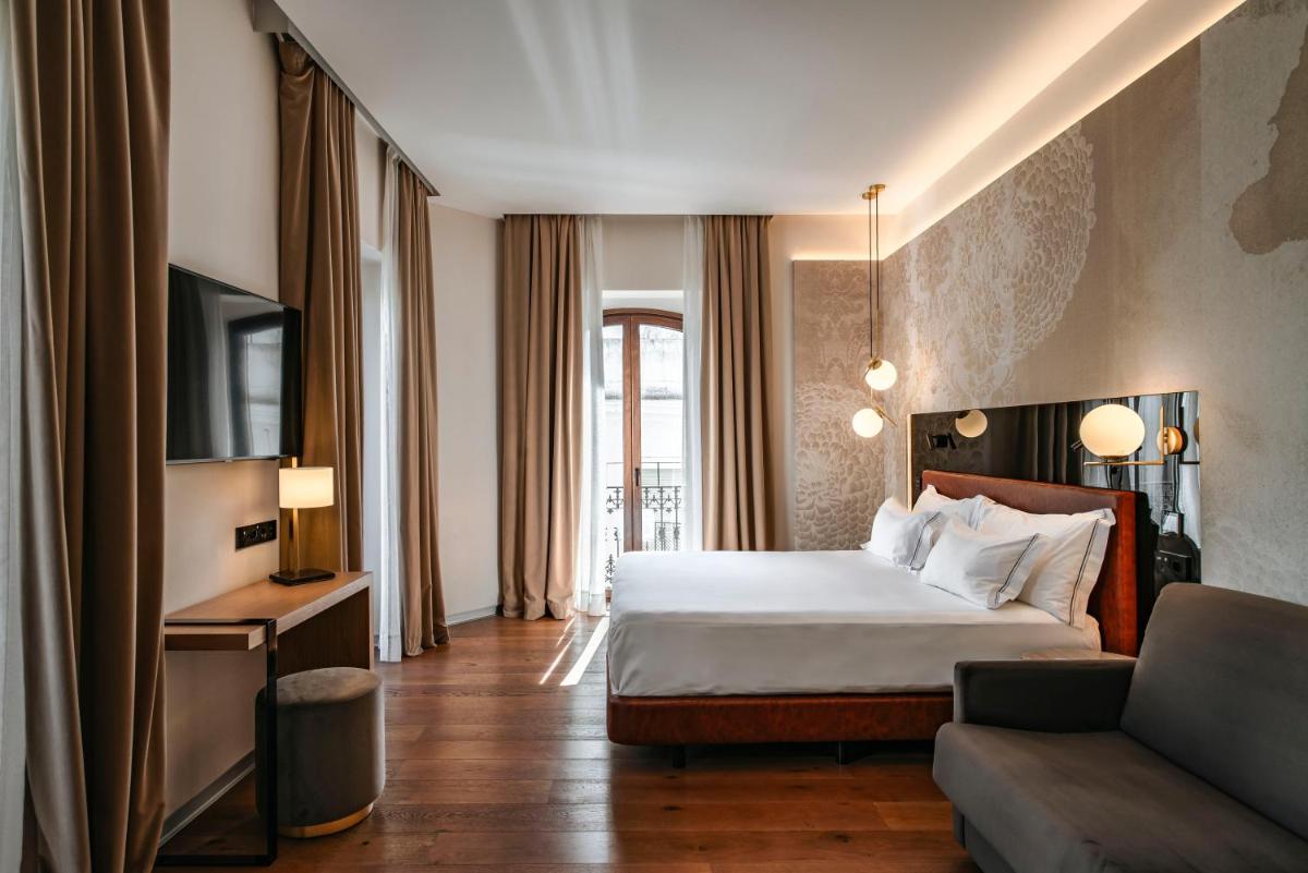 una habitación de hotel con una cama y un sofá en Vincci Selección Unuk 5 GL, en Sevilla