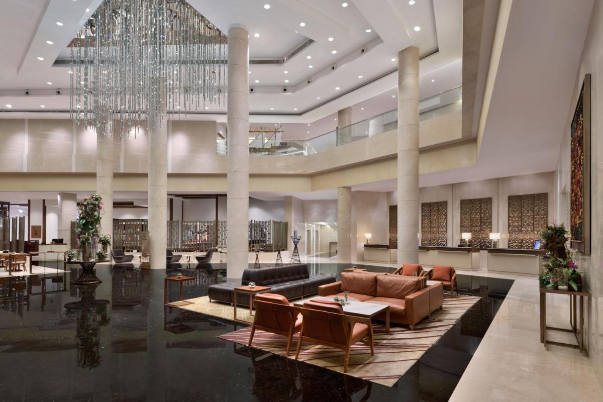a lobby of a hotel with a chandelier at Kochi Marriott Hotel in Cochin