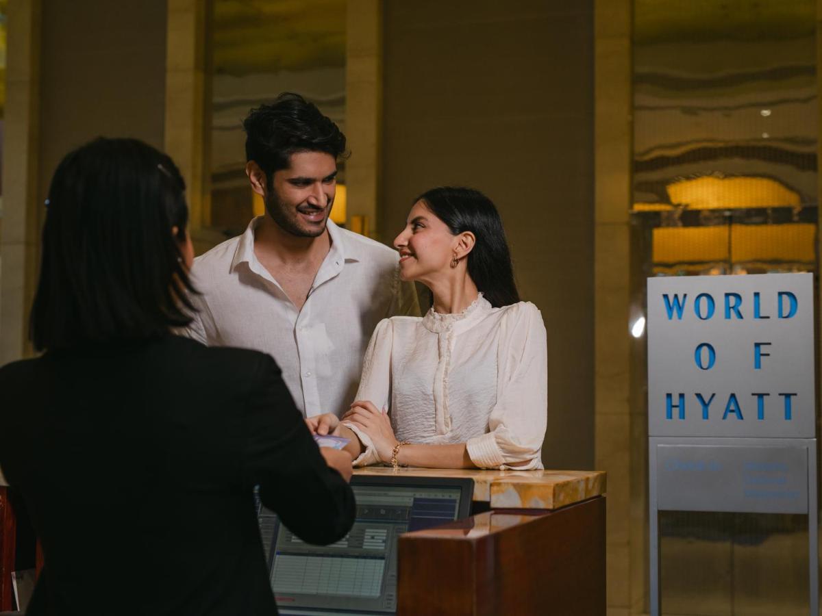 a man and a woman standing in front of a desk at Hyatt Regency Pune Hotel & Residences in Pune