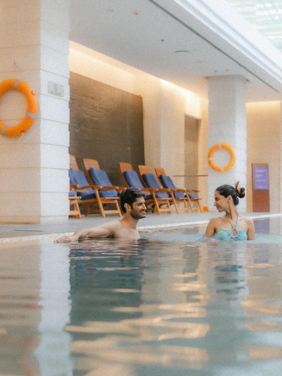 a man and a woman in a swimming pool at Hyatt Regency Pune Hotel & Residences in Pune