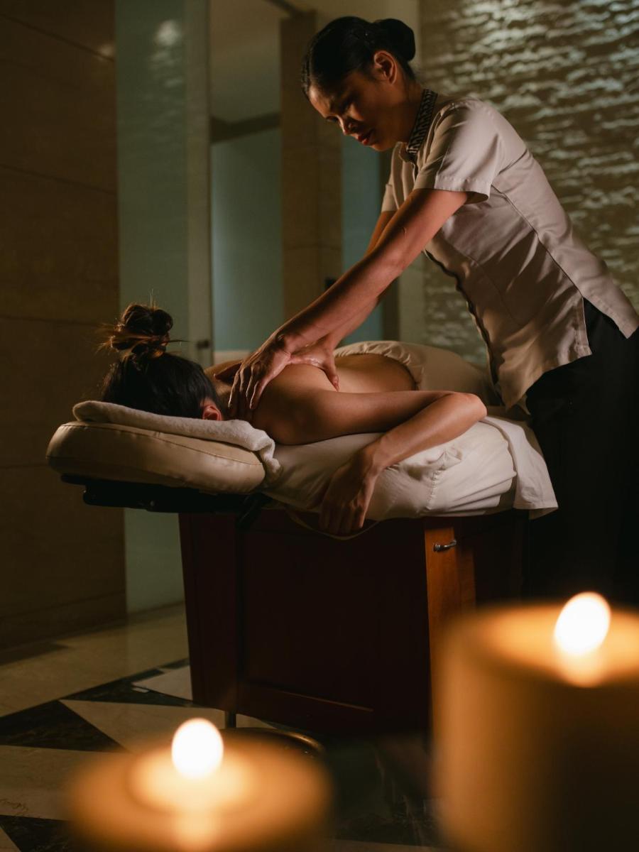 a woman is sitting on a bed in a bath room at Hyatt Regency Pune Hotel & Residences in Pune