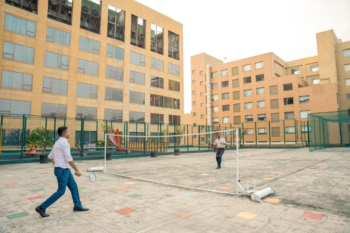 two men playing a game of volleyball in a courtyard at Hyatt Regency Pune Hotel & Residences in Pune