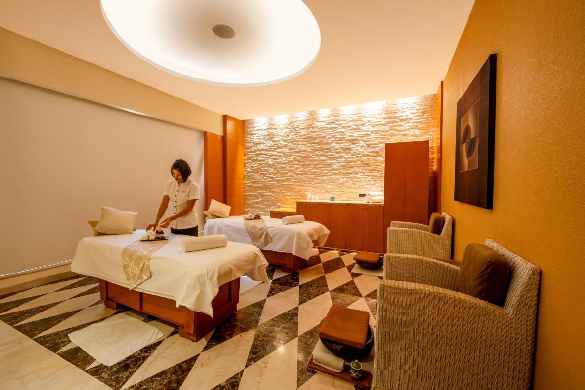 a woman standing in a hotel room with two beds at Hyatt Regency Pune Hotel & Residences in Pune