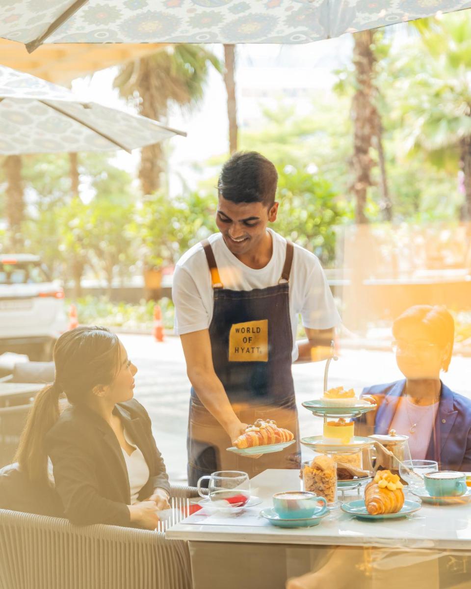 a man in an apron preparing food at a table at Hyatt Regency Pune Hotel & Residences in Pune