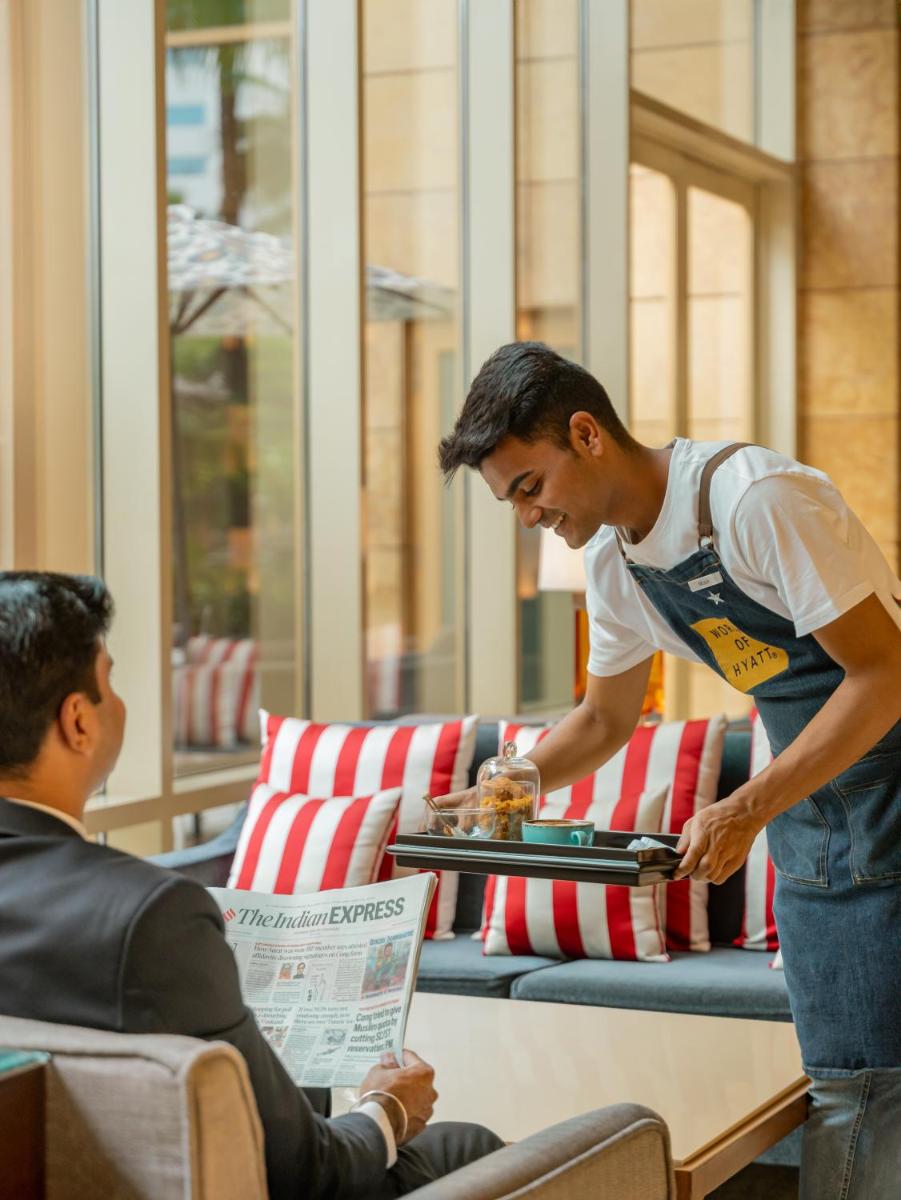 a man standing in a room with a man at Hyatt Regency Pune Hotel & Residences in Pune