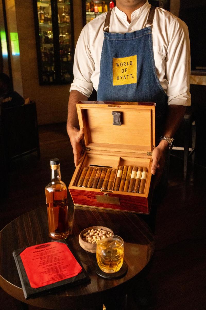 a man is holding a box of whiskey on a table at Hyatt Regency Pune Hotel & Residences in Pune