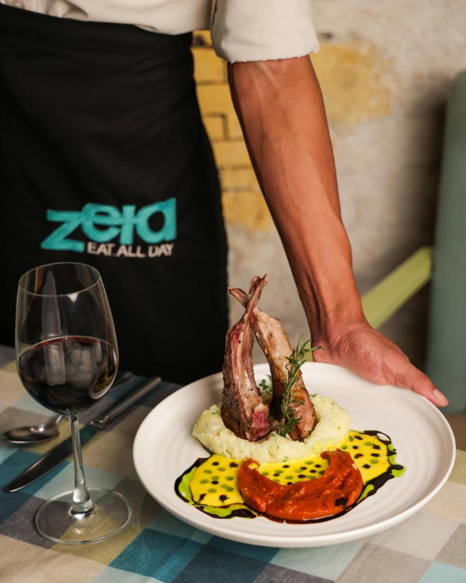 a person holding a plate of food and a glass of wine at Hyatt Regency Pune Hotel & Residences in Pune