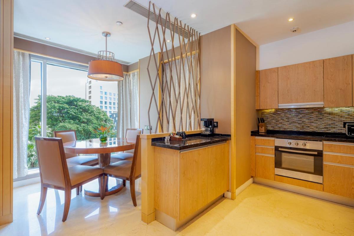 a kitchen with a table and a dining room at Hyatt Regency Pune Hotel & Residences in Pune