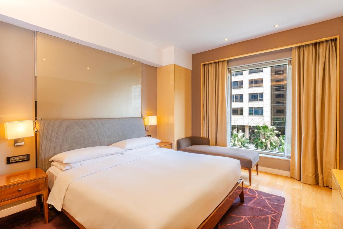 a bedroom with a large bed and a large window at Hyatt Regency Pune Hotel & Residences in Pune