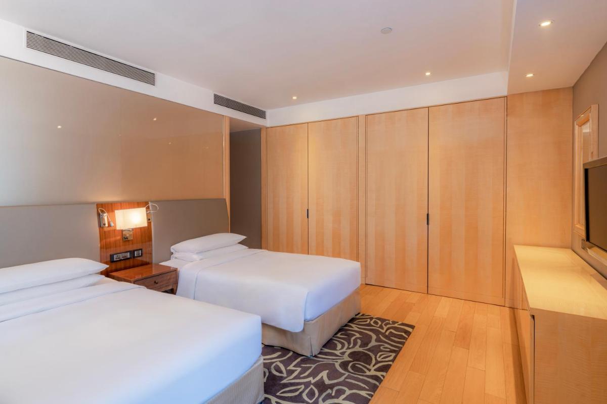 a hotel room with two beds and a flat screen tv at Hyatt Regency Pune Hotel & Residences in Pune