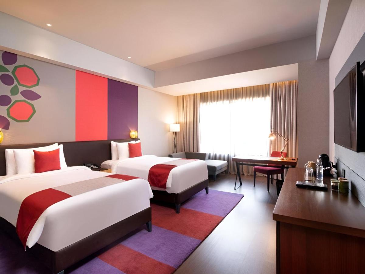 a hotel room with two beds and a flat screen tv at Grand Mercure Bengaluru at Gopalan Mall - An Accor Brand in Bengaluru a hotel room with two beds and a flat screen tv at Grand Mercure Bengaluru at Gopalan Mall - An Accor Brand in Bengaluru