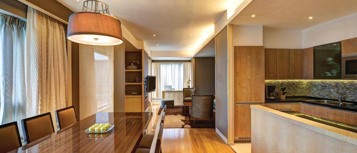 a kitchen with a long wooden table in a room at Hyatt Regency Pune Hotel & Residences in Pune