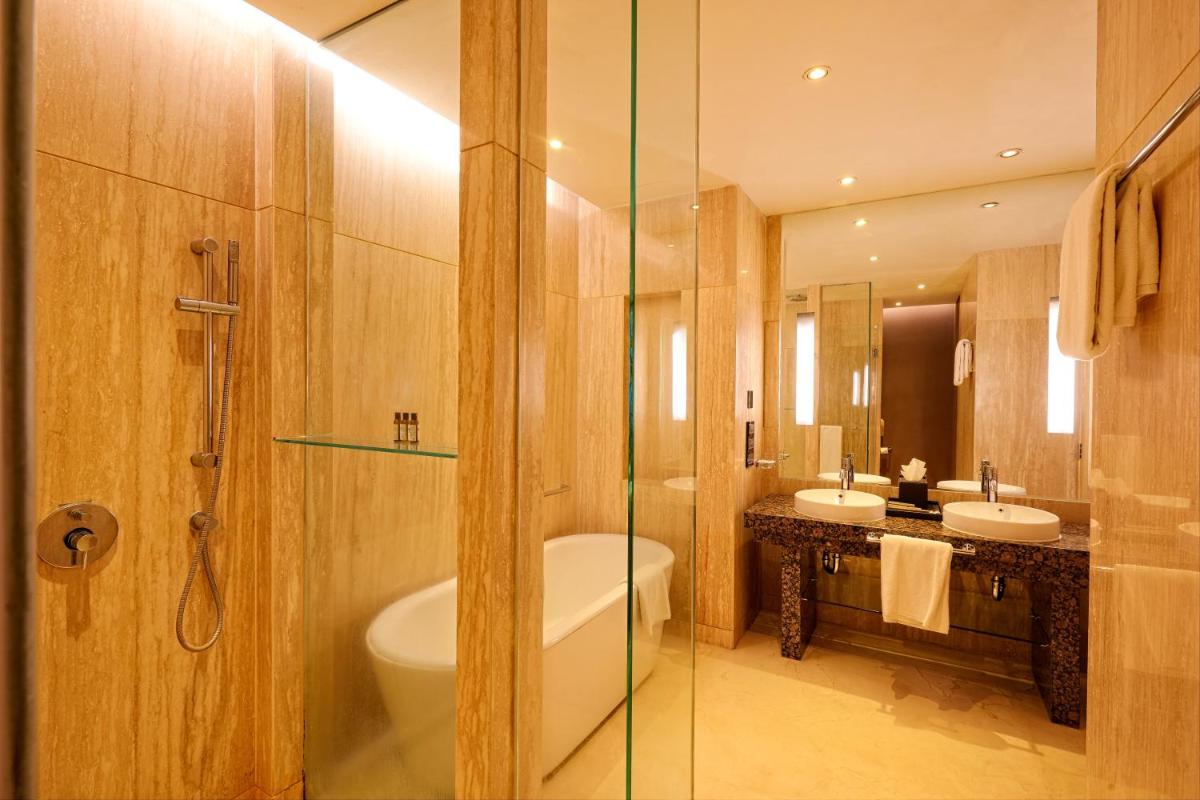 a bathroom with two sinks and a toilet and a shower at Hyatt Regency Pune Hotel & Residences in Pune
