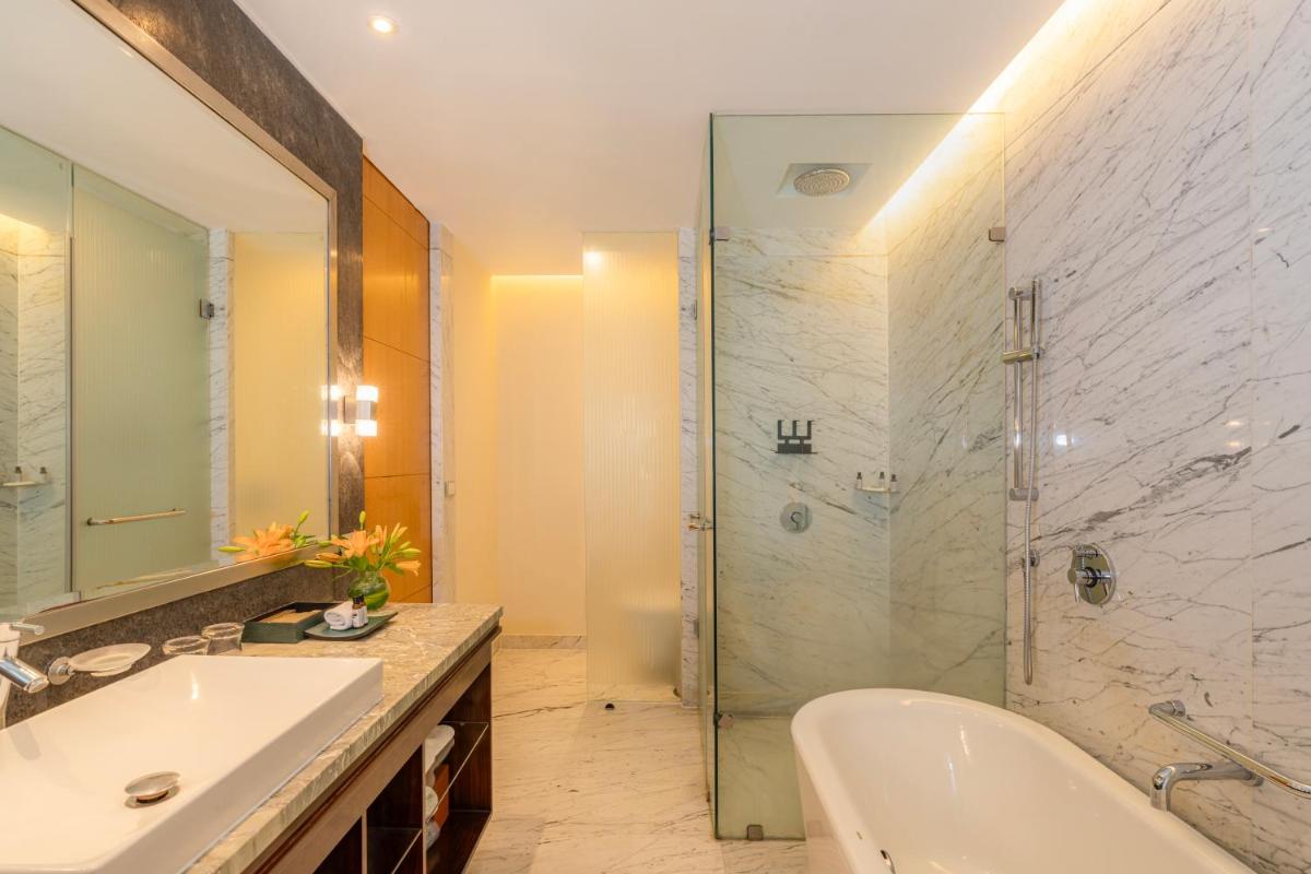 a bathroom with a tub and a sink and a shower at Hyatt Regency Pune Hotel & Residences in Pune