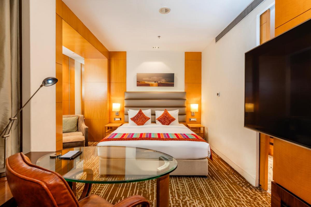 a hotel room with a bed and a tv at Hyatt Regency Pune Hotel & Residences in Pune